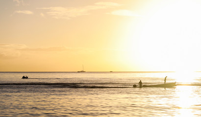 In St. Lucia at sunset the fisherman watches for fish in the traditional manner of standing in the boat. 