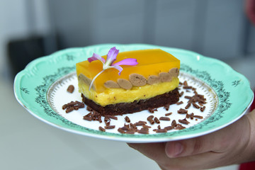 chocolate pie with passion fruit jelly decorated with edible flower, layered cake
