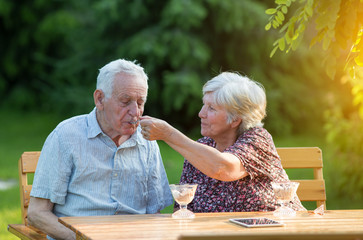 Old couple eating ice cream outside - Powered by Adobe
