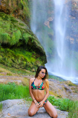 Obraz premium Sexy brunette model on waterfall background 
