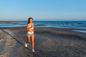 Young slim beautiful woman run on sunset having positive mood
