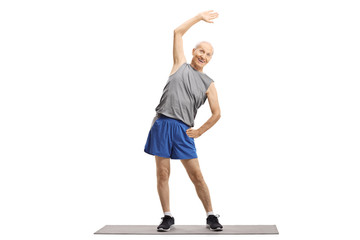 Elderly man doing a stretching exercise on a mat