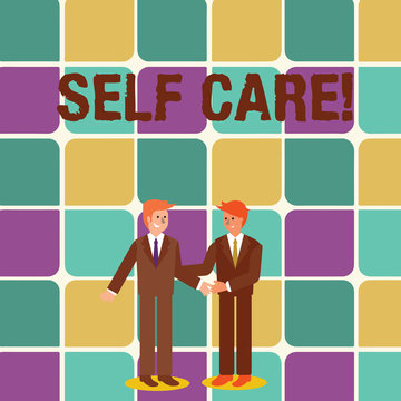 Text sign showing Self Care. Business photo showcasing practice of taking action to preserve or improve ones own health Two Businessmen Standing, Smiling and Greeting each other by Handshaking