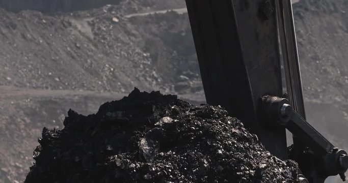 Slow motion loading of an excavator into mining truck. Excavator loading coal in big dump trucks. Coal as source of thermal energy. Loading of coal truck using excavator slow motion