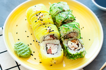 Sushi rolls on the plate with soy sauce and chopsticks. Japanese food close up