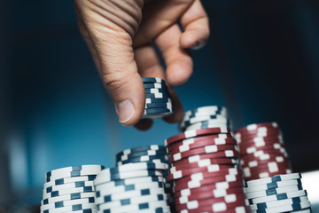 Successful man stacking poker chips at the casino