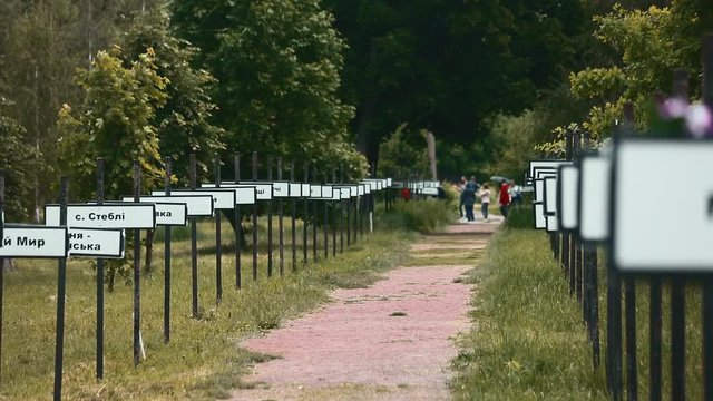 Summer in Chernobyl exclusion zone, Ukraine. Popular tourist attaction while sightseeing in Pripyat surroundings. Alley of memory with signs of villages names.