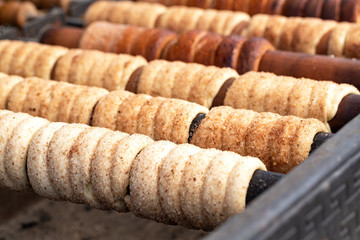 Trdelnik is street food of Prague. It considered a traditional national Czech sweet food. Trdelnik is tubes of sweet dough, cooked on an open fire. Selective focus.   