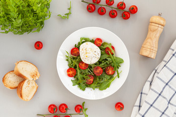 Burrata cheese. Salad of fresh arugula, cherry tomatoes and soft Italian cheese burrata with olive oil. Italian food. 