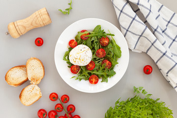 Burrata cheese. Salad of fresh arugula, cherry tomatoes and soft Italian cheese burrata with olive oil. Italian food. 