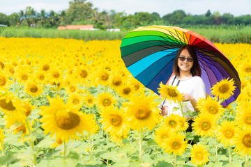 Fototapeta na wymiar woman holding an umbrella in a sunflower field.