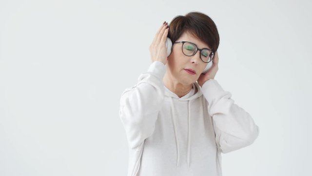 Hobby, interests and people concept - Beautiful woman 40-50 years old listening music in big headphone