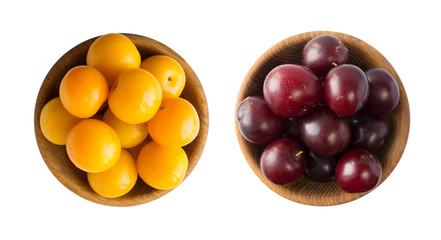 Yellow and red plums in a wooden bowl on white background. Plums isolated on white background. Vegetarian or healthy eating. Top view.