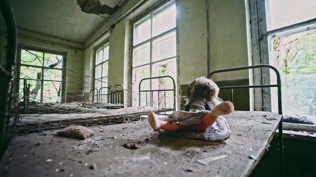 Chernobyl Zone in Ukraine. Interior inside destroyed old building with day care school in Prypiat. Close-up of abandoned beds and lost toys in shabby room.