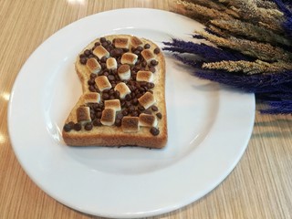 Toasted bread sprinkled with chocolate chips and marshmallows