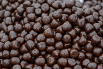 Dark brown chocolate dragee, background texture