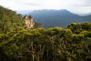 Two of the three sisters rock formation within the forest in the Blue mountains with orange last sunlight, Katoomba, New South Wales, Australia