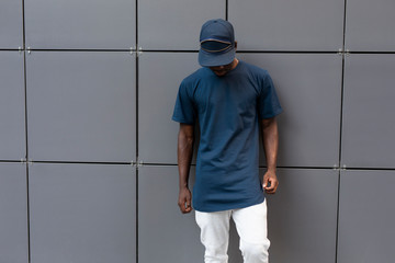 Empty blank t-shirt on the unrecognizable american man standing near wall
