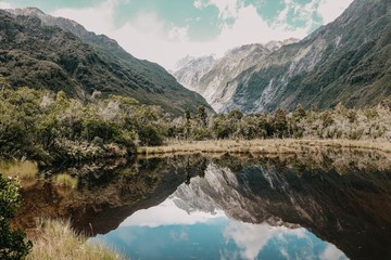 Fototapeta na wymiar Franz josef Glacier New Zealand lake reflections trees nature view