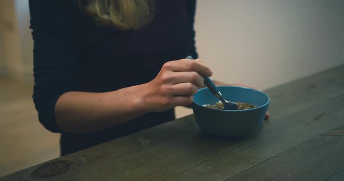 Young woman eating yogurt for breakfast