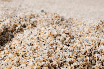The sand on the beach. Texture or background. Footprints in the dirty yellow sand. Tourist holiday concept.