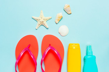 Summer beach sea accessories. Coral flip flops, shells, starfish, yellow sunscreen bottle, body...