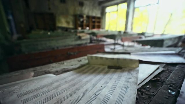 Chernobyl, Ukraine. Close-up of old kids things left on desks in an abandoned music school in Prypiat city. View inside the classroom with peeling paint and dust.