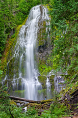 Hiker man in far distance pointing at massive waterfall