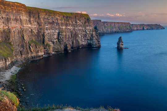 The stunning and majestic Cliffs of Moher in County Clare, Ireland at sunset, beautiful pink sky taken from Luca Lookout