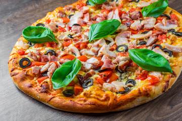 Pizza with Chicken meat, Mozzarella cheese, tomato, olive. Italian pizza on wooden background
