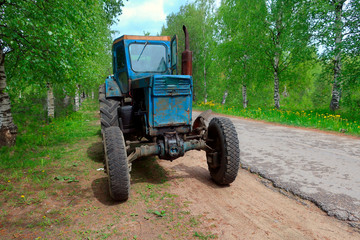 old rusty farm tractor parked on the side of a country road