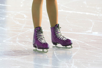 feet on the skates of a person rolling on the ice rink