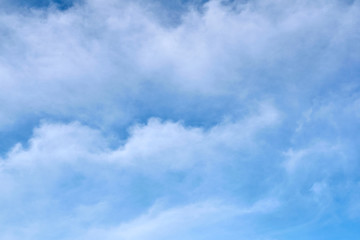 Blue sky with undulating clouds. The background is textured.