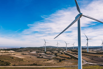 Birds eye view of windmills station with green energy resources generation from wind power on scenic vast area of agriculture fields.Alternative electricity production with rotating turbines in meadow