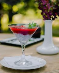 Strawberry-creamy dessert with chia seeds in a glass dish is on the table. Healthy food.