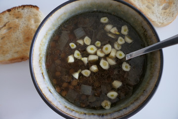 Warm Homemade Lentils Soup with Garlic and Bread Slices isolated on a White Background