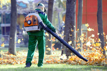Working in the Park removes leaves with a blower