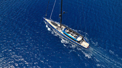 Aerial drone photo of beautiful wooden deck sail boat cruising the deep blue sea of Mykonos island, Cyclades, Greece