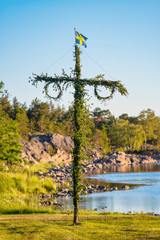 Obraz premium Sunrise of a classic midsommer pole at the coast line of Roslagen