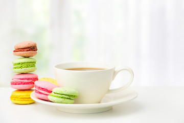 Fototapeta na wymiar French macarons and a mug of tea on the table