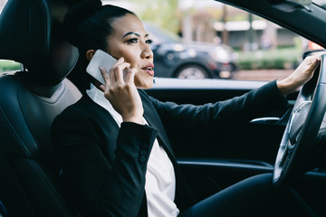 Attractive woman proud eo dressed in formal wear phoning to partner for talking about accounting and business contract while driving own car, experienced executive manager consultancy via app