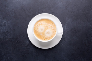 Cup of coffee on black stone background Top view