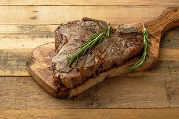 Marbled beef steak on rosemary board, on wooden background, restaurant menu, gastronomy, delicious food