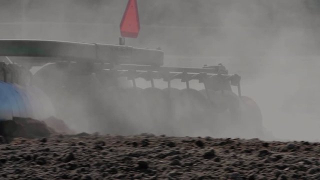 Tractor Pulling Disc Harrow Through Field in Preparation for Planting, Agriculture, Canada