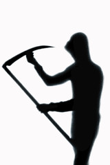 Dangerous man behind frosted glass with a scythe in his hand. Halloween. Black and white image.