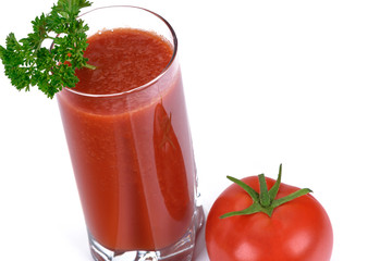 Healthy eating concept - juice from fresh tomatoes with parsley in glass next to a whole tomato isolated on a white background