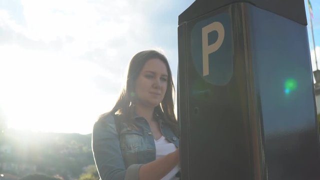Woman using parking machine on the street.