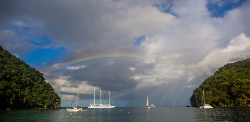 Naklejka na ściany i meble Beautiful rainbow across the ocean over boats in the Caribbean Sea. 