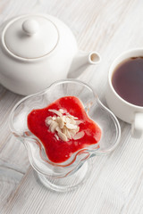 Sugar free panna cotta, based on coconut milk, strawberry puree, orange jelly, decorated with flaked almonds with a cup of black tea is a perfect dietary treat