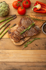 Steak with vegetables on a wooden background, restaurant and hotel business, menu, homemade recipes, culinary background, vertical photo, banner